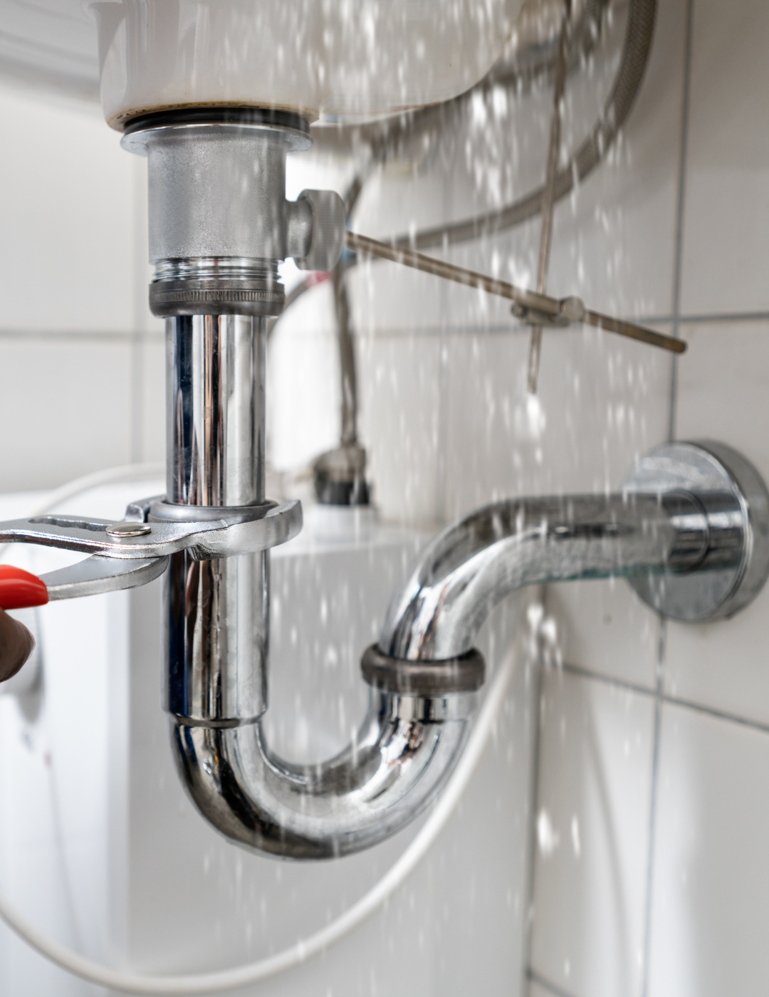Ik zie een lekkende wastafel waarbij een monteur met een pijpsleutel de afvoerbuis vastzet om het druppelen te stoppen. Het betreft een professionele loodgietersservice voor reparatie en onderhoud van huishoudelijke leidingen. Het hoofddoel is om de lekkage snel te verhelpen en de waterafvoer weer volledig afdichtend te maken. Op basis van de foto kun je afleiden dat er gewerkt wordt met hoogwaardige, chroomgeplaatste buizen die roestbestendig zijn en een strak uiterlijk hebben, dat de monteur vakkundig te werk gaat met een speciale pijpsleutel voor een nauwkeurige aansluiting en dat flexibele aansluitingen in de achtergrond zorgen voor een soepele en probleemloze installatie.